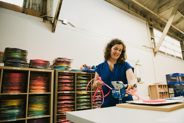woman in workshop measuring pink biothane