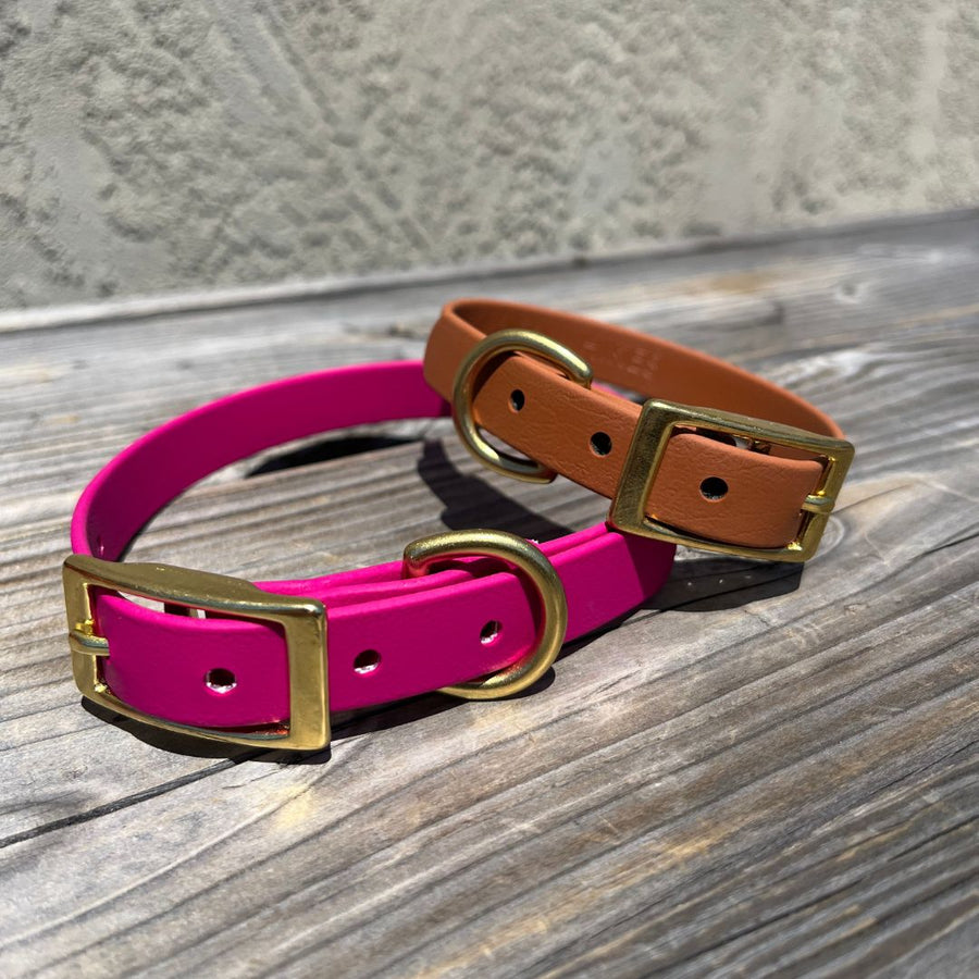 pink and caramel classic biothane collar for small dogs with brass hardware on a wood table