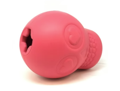 Large pink skull chewable dog toy and treat dispenser laying on its side showing the opening for treats