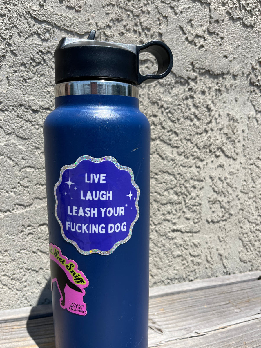 blue water bottle displaying blue and silver sticker that says "Live Laugh Leash your $ucking Dog"