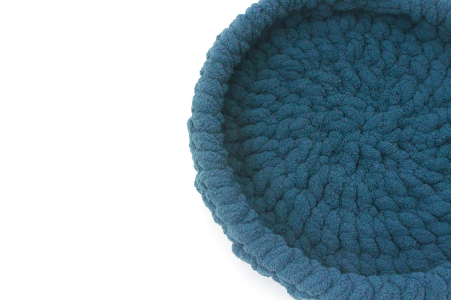 close up of ocean blue crocheted pet bed from little noses boutique on a white background