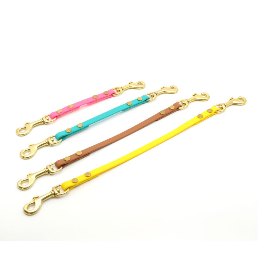 four sizes of biothane safety strap with brass hardware on a white background