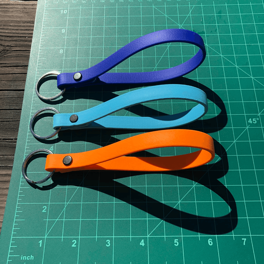 Green Ruler board with three Biothane Key fobs showing their size