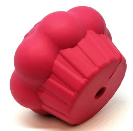 Pink rubber treat dispenser on its left side