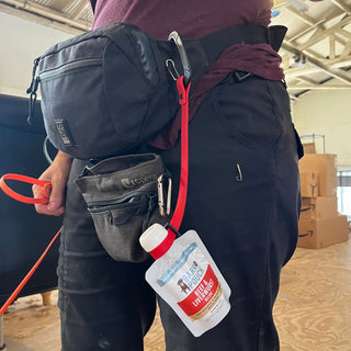 person wearing a belt bag, with a carabineer attached to a bark pouch for easy access