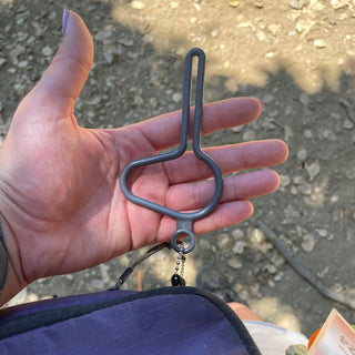person holding the dooloop dog waste bag holder in the hand 