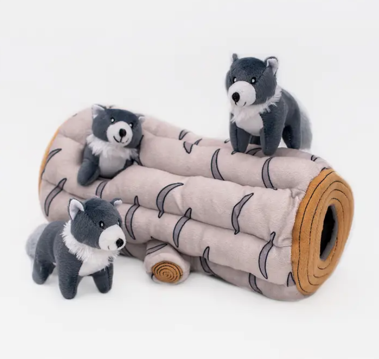 close up of log burrow toy for dogs with three wolves
