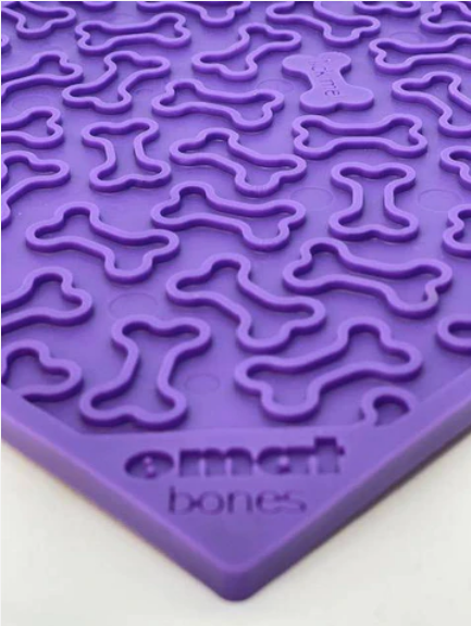close up of emat dog enrichment lick mat with purple bones design