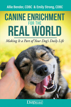 a photo of the book "canine enrichment for the real world" shows a photo of a relaxed shepherd dog with a hand stroking it's face. 