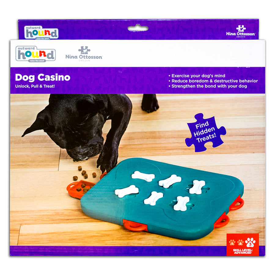 Nina Ottosson Dog Casino Toy with sliding compartments for treats in orange, teal and white in purple and white package