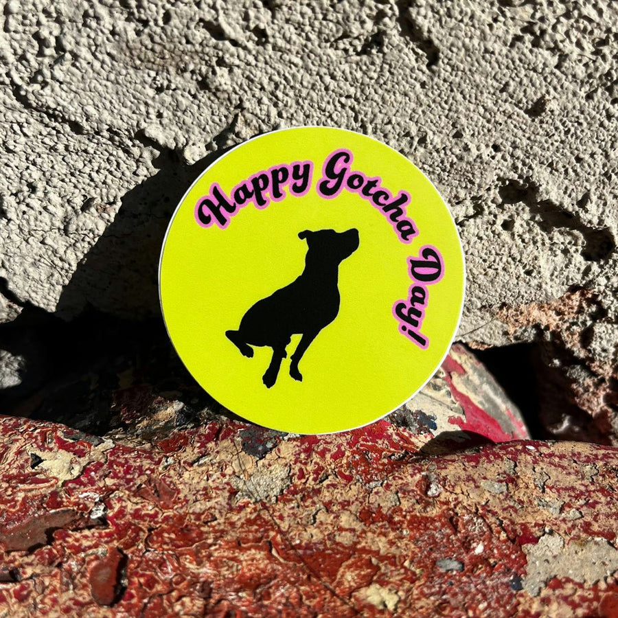 bright green round sticker with black dog and the pink words stating Happy Gotcha Day with a brick background