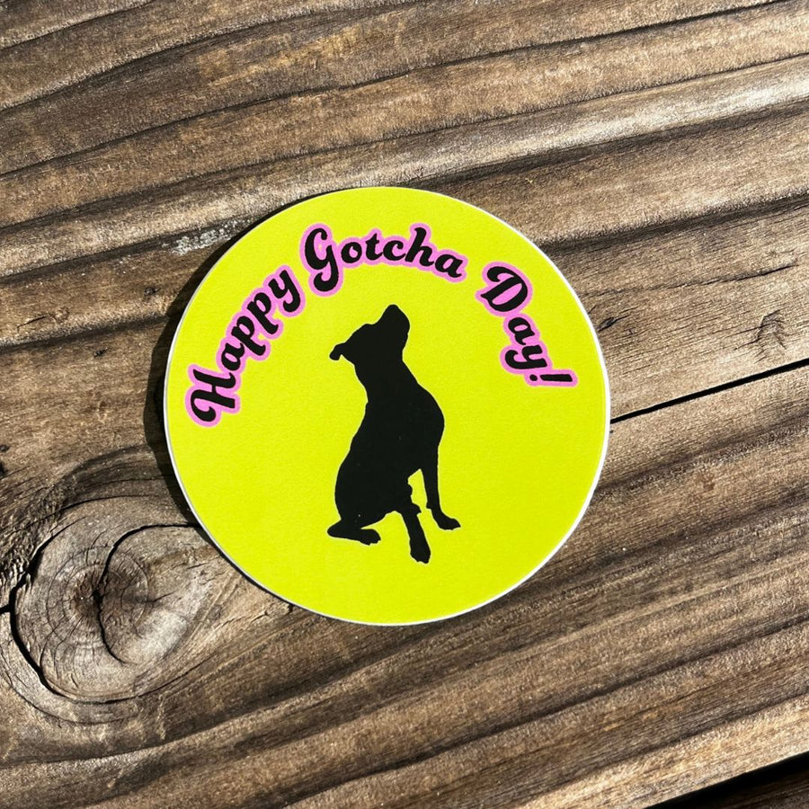 bright green round sticker with black dog and the pink words stating Happy Gotcha Day on a wood blackground