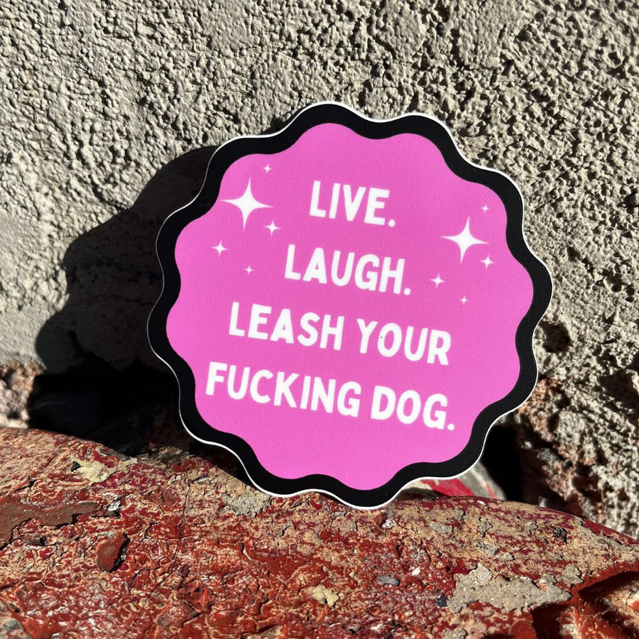pink round stick with black trim, white letters that say Live, Laugh, Leash your Fucking Dog