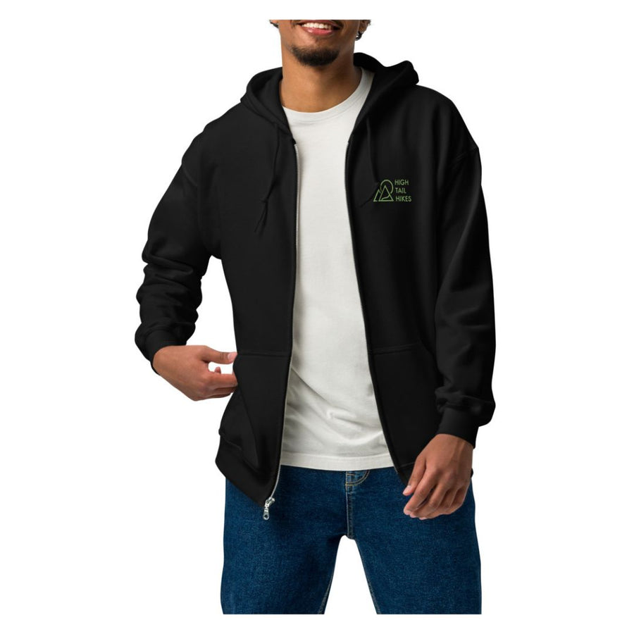 man wearing black zip up hoodie with green high tail hikes logo on the front left chest area - unzipped with white t-shirt
