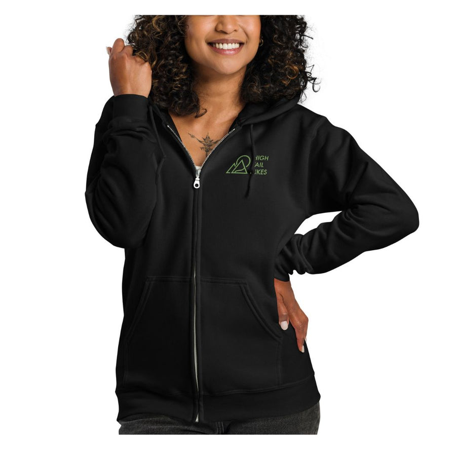 woman wearing black zip up hoodie with green high tail hikes logo on the front left chest area