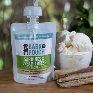 White, Tan, and green Back Pouch dog treats in Sardines and Cream Cheese recipe on a table next to meat and a bowl of cream cheese
