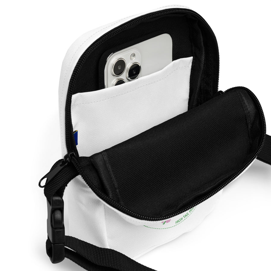 inside of white crossbody bag with a cell phone to show size 
