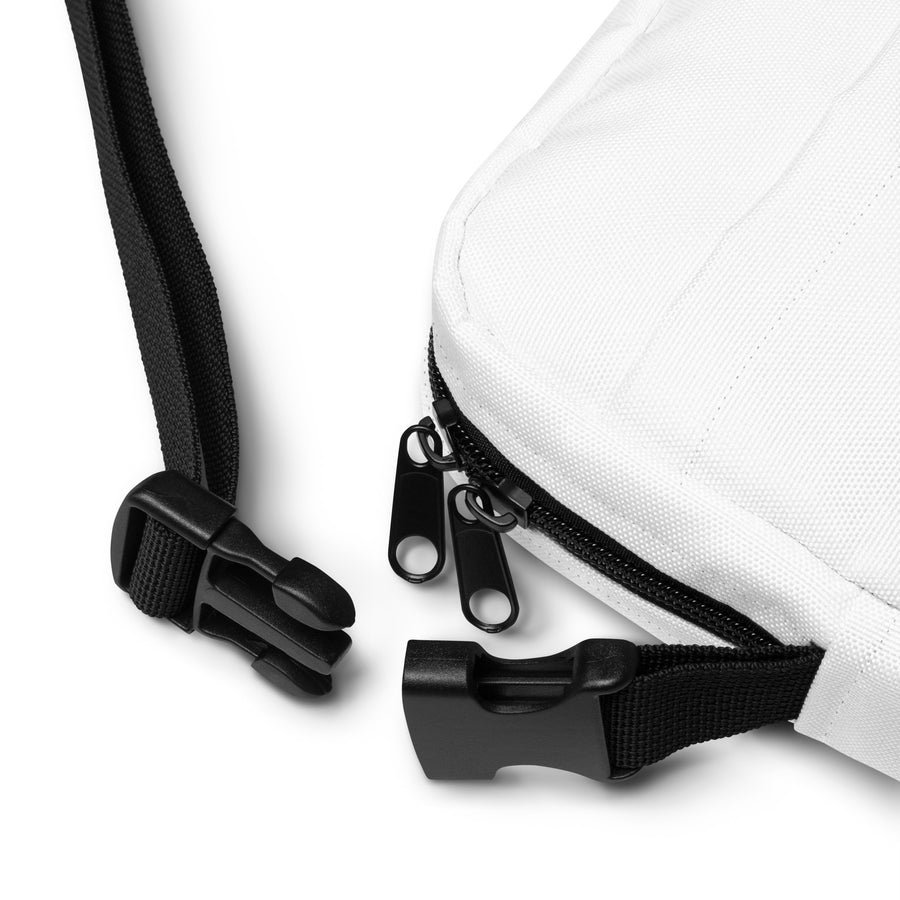 close up of strap of crossbody bag with plastic buckle and zippers