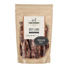 white background, tan package with jerky looking meat strips for dogs behind a clear cover, off white label that reads "Farm Hounds Treats, Beef Lung, Humanly Raised by Thousand Hills farms"
