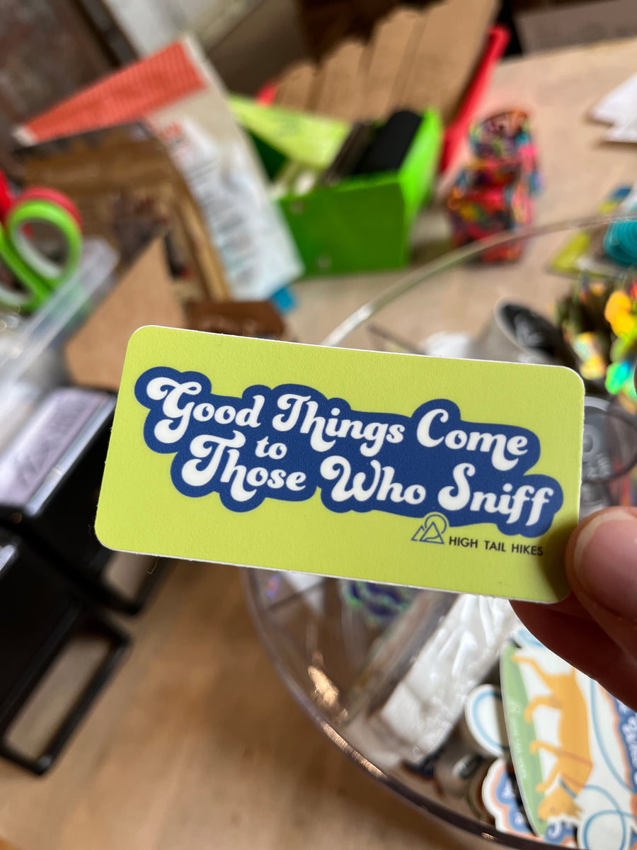 yellow rectangle stick that says "Good Things Come to Those Who Sniff" held by a hand