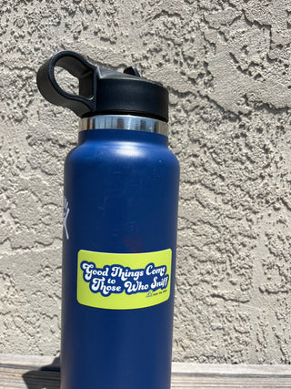 yellow rectangle stick that says "Good Things Come to Those Who Sniff" on a blue water bottle