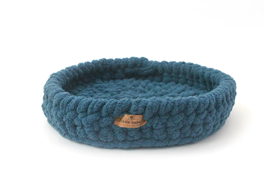 ocean blue crocheted pet bed from little noses boutique on a white background