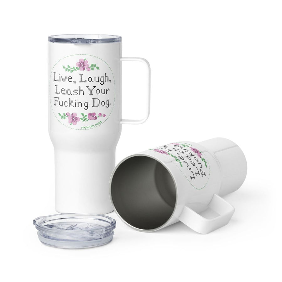 two white travel mugs - left mug is standing, right mug is laying with the lid off in front of it - they both read in cross stitch print - "Live, Laugh, Leash Your F Dog"