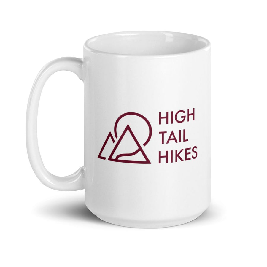 close up of white 15 oz ceramic mug with red high tail hikes logo, handle to the left