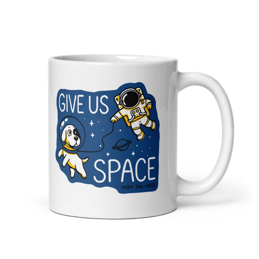 11 oz white ceramic mug that has a blue graphic of a dog and astronaut in space that reads "Give Us SPace"