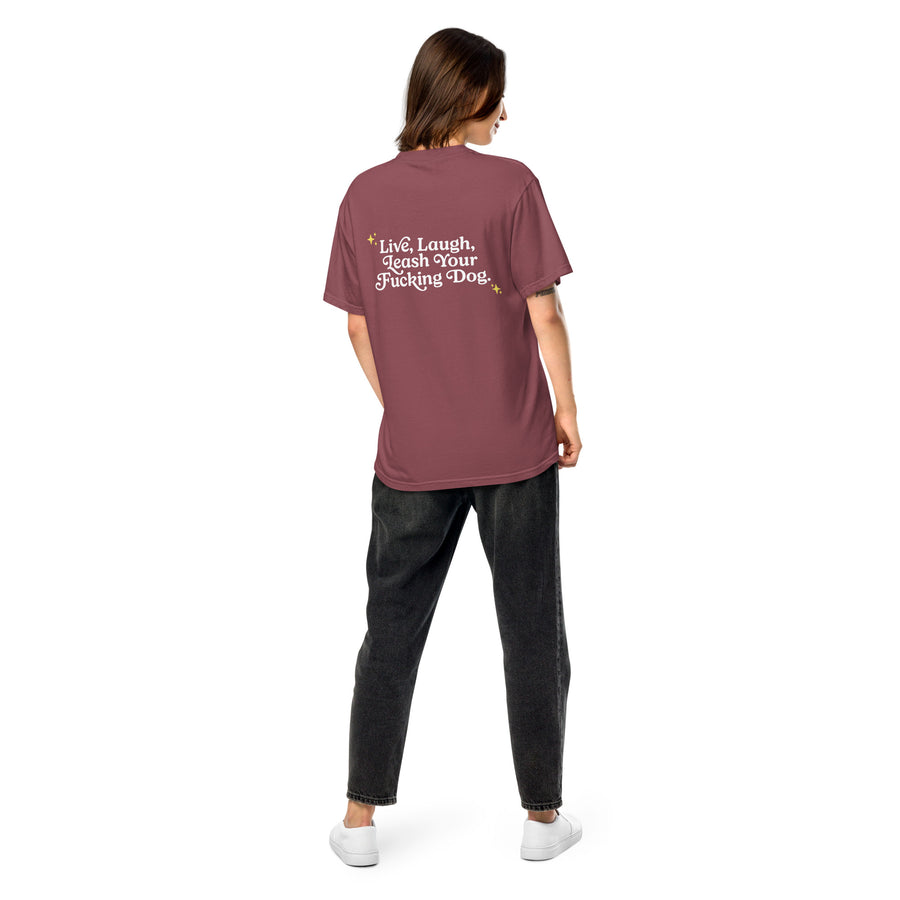 person showing the back of brick red colored unisex t-shirt that reads "Live, Laugh, Leash Your F Dog" in white letters and gold stars in the coroners