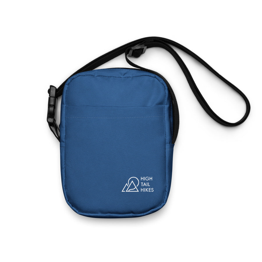 blue crossbody bag with black adjustable strap, high tail hikes while logo in corner
