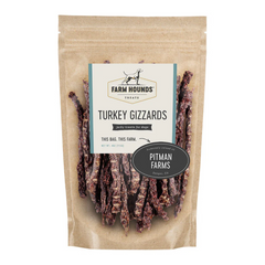 white background, tan package with jerky looking meat strips for dogs behind a clear cover, off white label that reads "Farm Hounds Treats, Turkey Gizzards, Humanly raised by Pitman Farms"