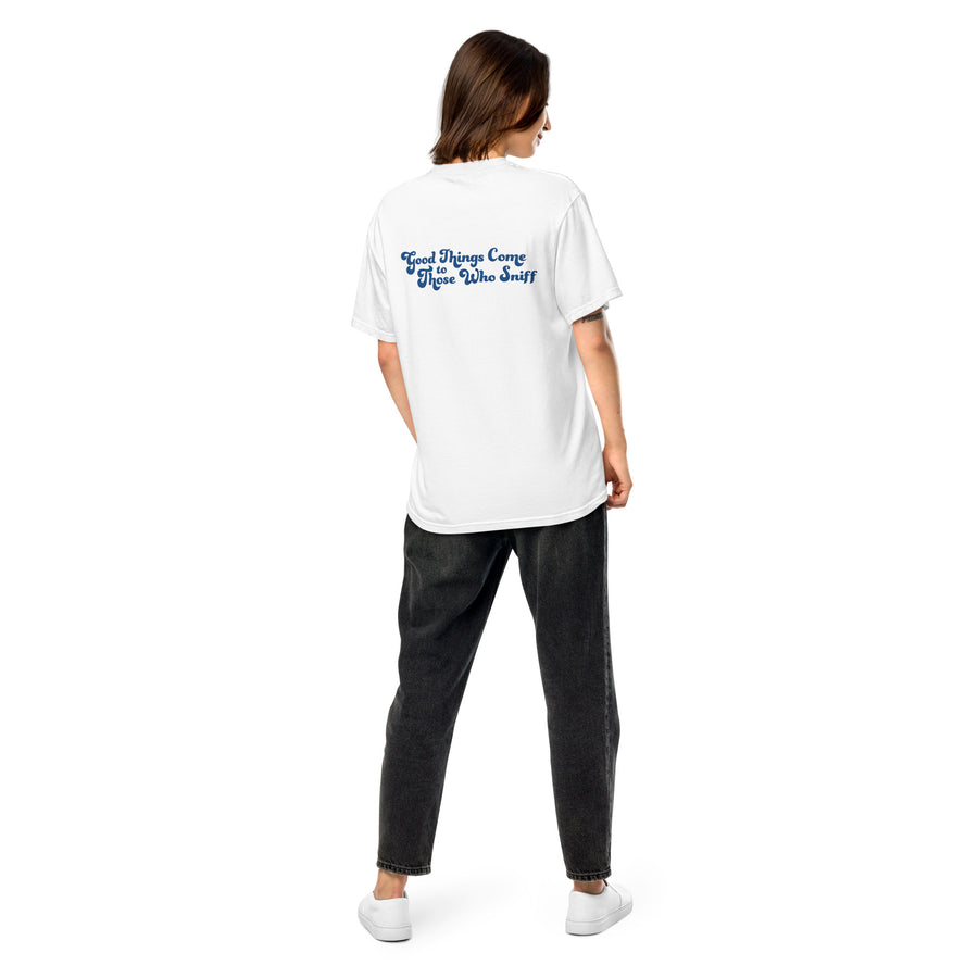 person facing away from camera, showing the back of white unisex tee that reads "Good Things Come to Those Wo Sniff" in blue letters
