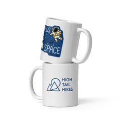 two white ceramic 11 oz mugs stacked - top mug shows a picture of space an astronaut that reads "Give Us Space" while the bottom mug has a blue High Tail Hikes logo