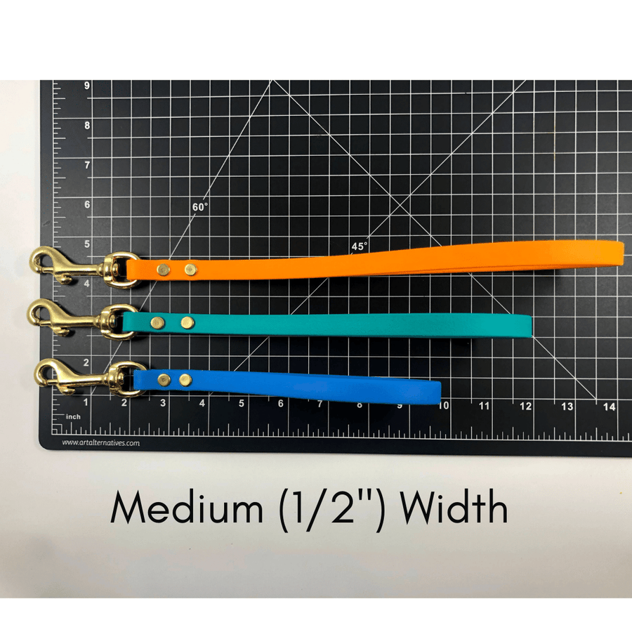 black ruler mat with three biothane traffice handles showing their length in medium 1/2" width