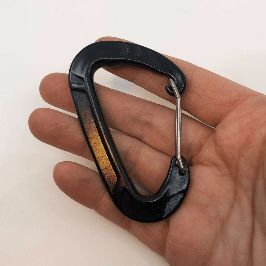 persons hand palm up holding a black carabiner