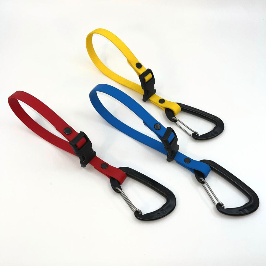 red, blue and yellow biothane quick release long line keepers on a white background