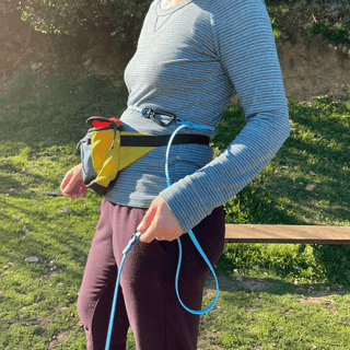 close up of womens waist wearing hands free convertible biothane dog leash holding the sport hardware