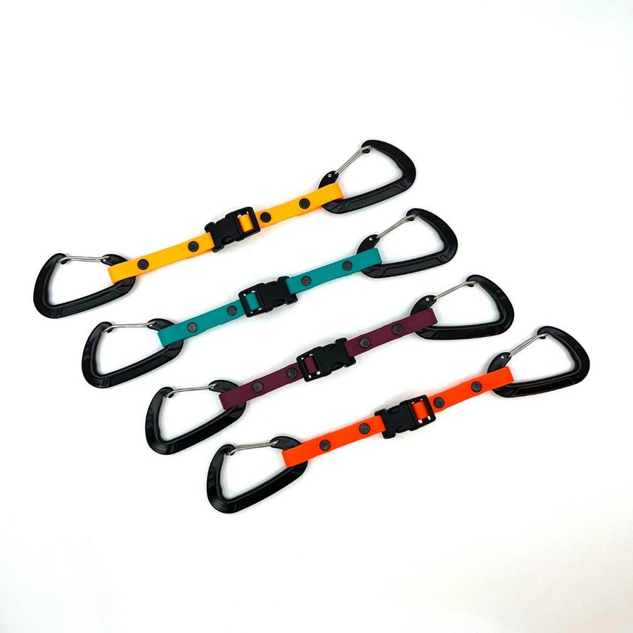 four different colored biothane waist to leash straps with sport hardware on a white background