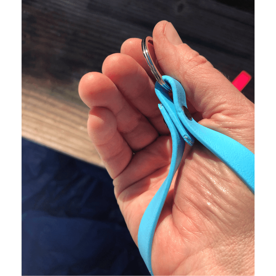 persons hand, palm up, holding onto the biothane key fob around their wrist