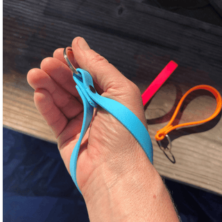 persons hand, palm up, holding onto the biothane key fob around their wrist