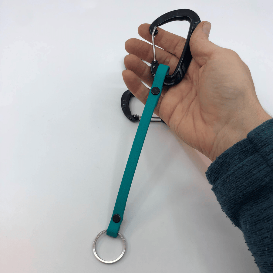 hand holding a biothane clicker strap with carabiner 