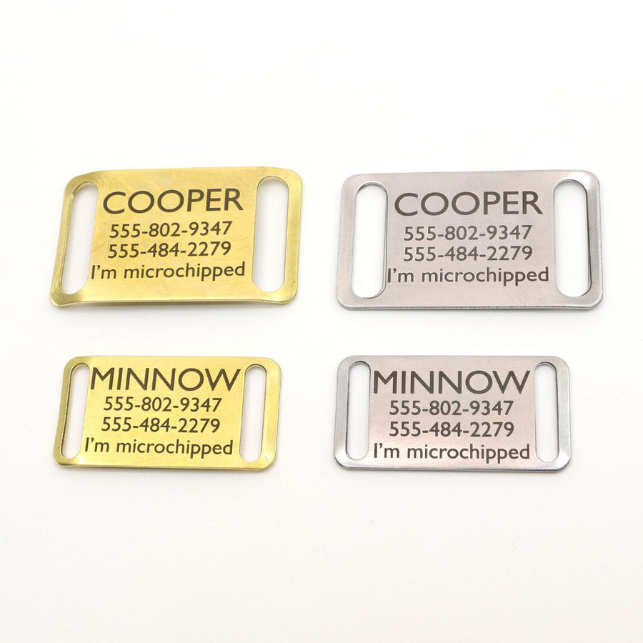 2 silver and 2 brass slide on dog ID tags with the pets name, 2 phone numbers and a note saying "I'm microchipped"