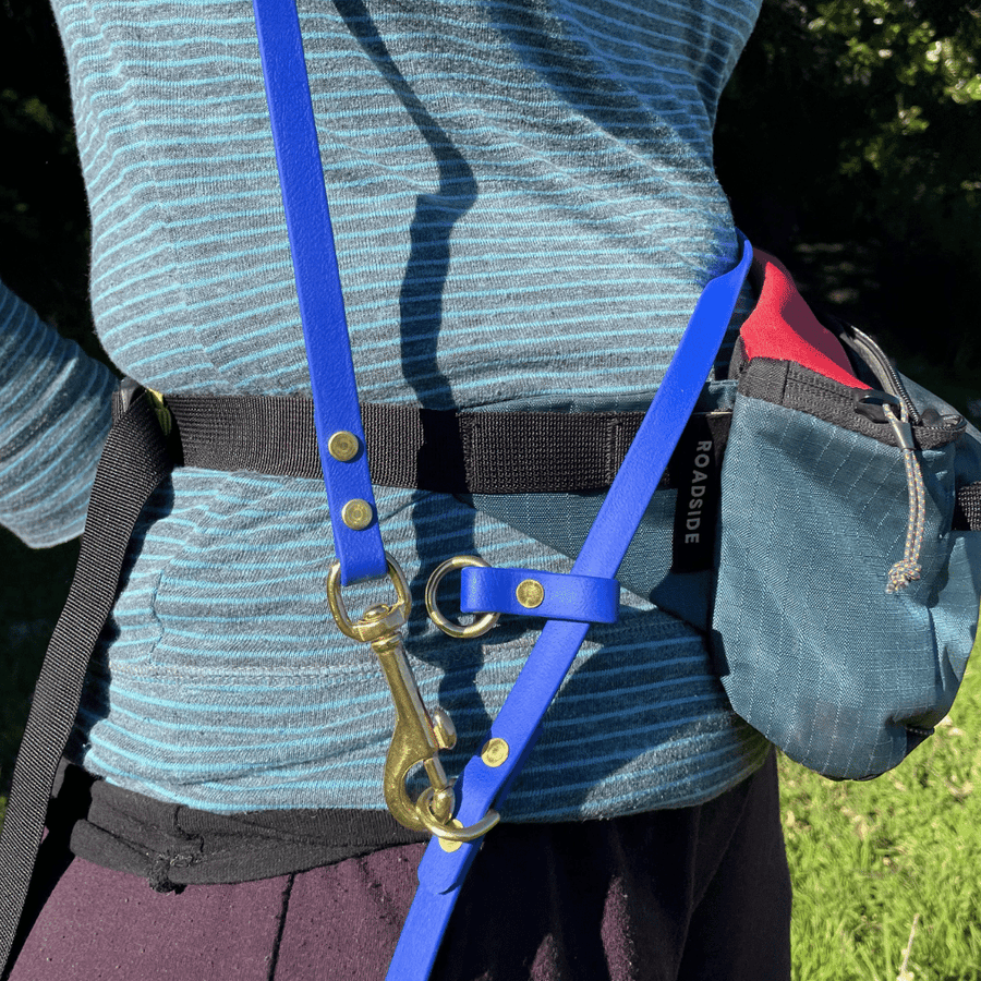 close up of women wearing biothane long hands free dog leash and brass hardware 