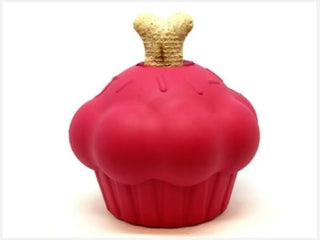 Pink rubber treat dispenser with a treat coming out the top