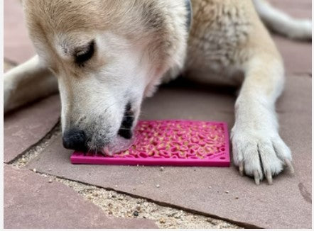 dog licking pink enrichment mat