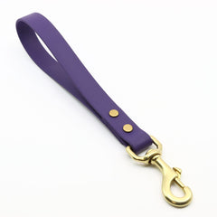 Violet biothane traffic handle with brass hardware on white background