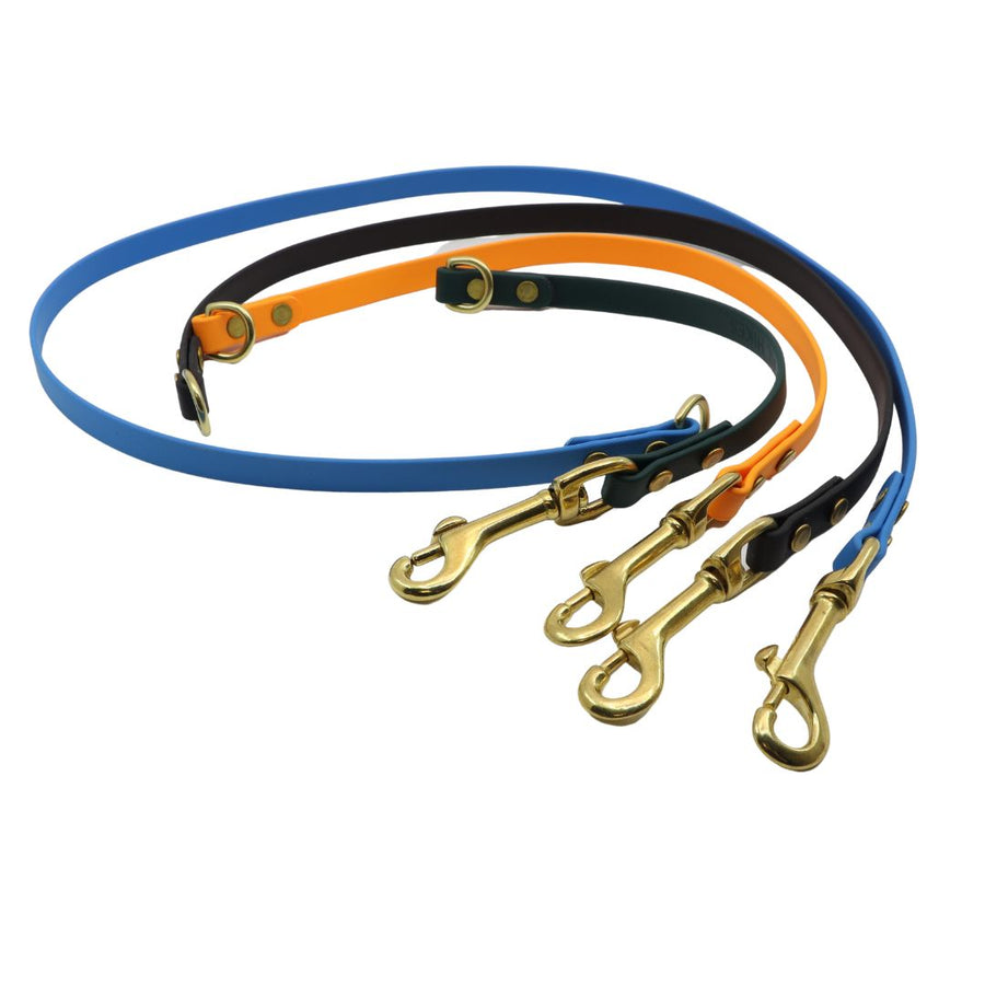 four biothane leash extenders curled together on a white back ground with brass hardware