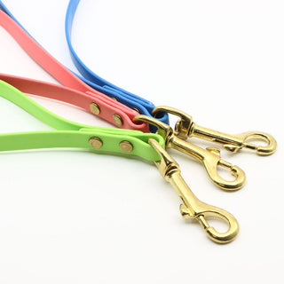 three biothane traffic handles with brass hardware together on a white background