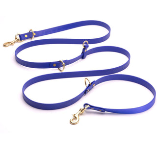 long dark blue biothane dog leash with brass hardware on white background